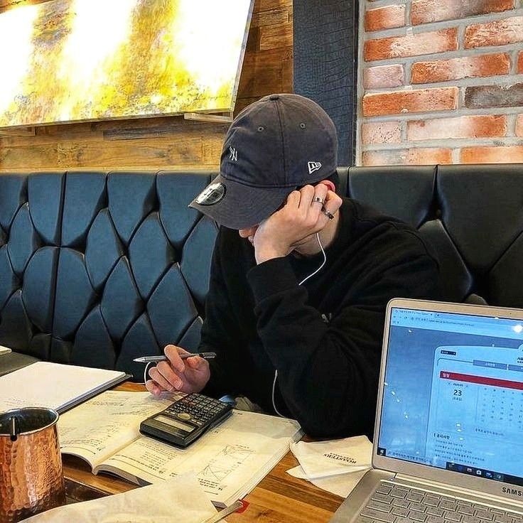 A learner studying with a laptop and notes